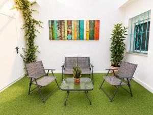 a room with three chairs and a table and a painting at Villa Maravilla in Seville