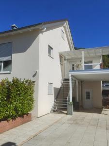 a white house with a stairway in front of it at Loft apartment für bis zu 4 Personen in Malterdingen