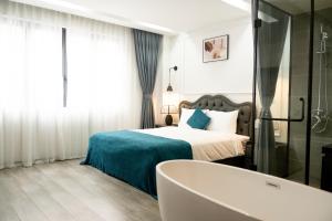 a bedroom with a bed and a bath tub at HC Homestay Ocean Park 23 in Cửu Cảo