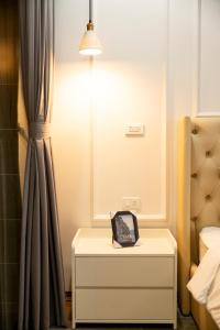 a nightstand with a clock on it in a bedroom at HC Homestay Ocean Park 23 in Cửu Cảo