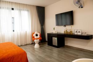 a bedroom with a television and a stuffed animal in a chair at HC Homestay Ocean Park 23 in Cửu Cảo