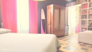 a bedroom with a bed and a room with a surfboard at Matilde Rooms in La Spezia