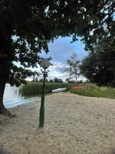 a green pole in the sand next to a body of water at Willa Sarenka in Radzyń