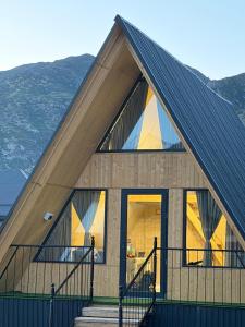 a house with a gambrel roof with glass windows at Kolsay A-Frame Yessen in Saty +8 photos