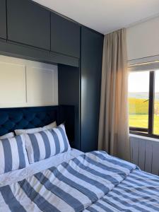 a bedroom with a bed with blue walls and a window at Sperrin View in Omagh