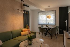 a living room with a green couch and a table at Luxury Opus Osijek - Self Check in, Free Private Parking in Osijek