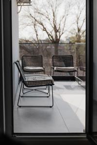 two chairs sitting on a patio outside a window at Luxury Opus Osijek - Self Check in, Free Private Parking in Osijek