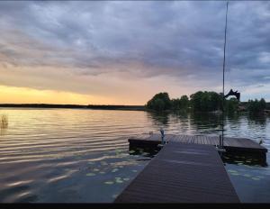 a dock on a body of water with a sunset at Willa Sarenka in Radzyń