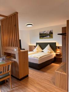 a bedroom with a bed and a wooden floor at Landhotel Bärnriegel in Mauth +50 photos