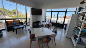 a living room with a table and chairs at Hostal Noray in Punta Prima