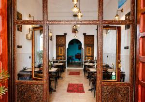 a dining room with tables and a large wooden door at Dar Albanin in Fez