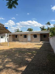 a house in a field with a building at Cantinho da Nonna in Morretes