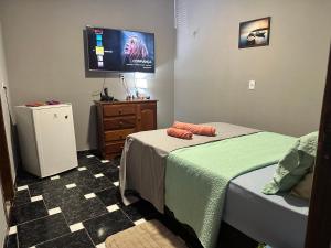 a bedroom with a bed and a flat screen tv at Villa Serena in Castanhal