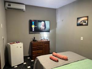 a bedroom with a bed and a flat screen tv at Villa Serena in Castanhal