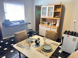 a dining room with a table and a kitchen at Villa Serena in Castanhal +8 photos