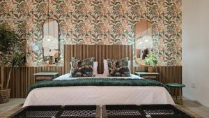 a bedroom with a bed with floral wallpaper and mirrors at Khaya Kwalata in Marloth Park