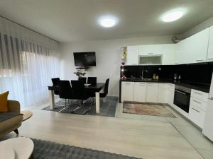 a kitchen and living room with a table and a dining room at Prishtina Guests in Prishtinë