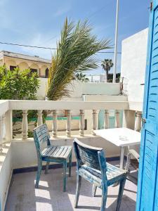 two chairs and a table on a balcony at Yousurf Surf House in Essaouira
