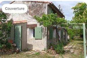 an old stone house with green shutters at Le cabanon in Valensole