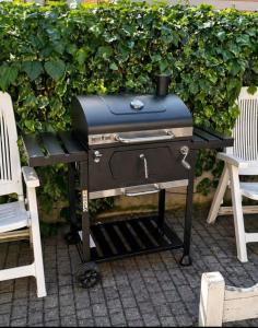 a grill sitting on a table next to two chairs at L'isola felice in Cecina