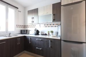 a kitchen with brown cabinets and a stainless steel refrigerator at Paseo Imperial in Arcos de la Frontera
