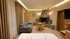 a bedroom with a couch and a living room with a fireplace at Perla e Tomorrit EZ in Ujanik