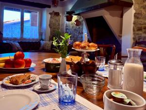 a table topped with plates of food and milk at RoncoBèrtolo R&B in Loiano +33 photos