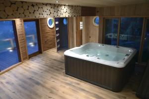 a large bath tub in a room with windows at Hotel Antukenu y SPA in Achao +57 photos