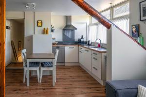 a kitchen with a table and a white refrigerator at De Parel van Pekel in Nieuwe Pekela