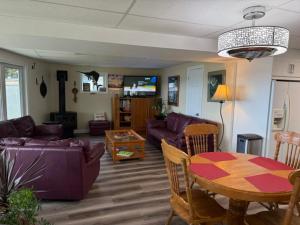 a living room with a purple couch and a table at N' This on the Bay -Vacation Suite in Wiarton