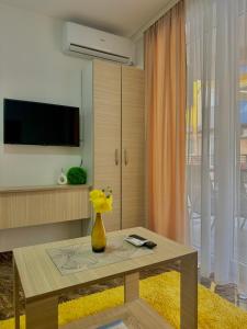 a living room with a table and a tv at Prenoćište SILVER LUX Srebrno Jezero in Veliko Gradište