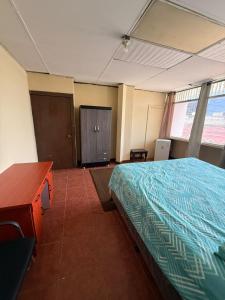 a room with a bed and a desk and window at casa zona 10 in Lo de Contreras
