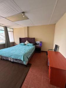 a bedroom with a bed and a desk with a television at casa zona 10 in Lo de Contreras