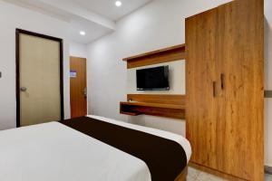 a bedroom with a bed and a flat screen tv at Super Collection O Lorven Grand in Visakhapatnam +23 photos