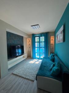 a living room with a bed and a flat screen tv at Balaton Vibe Apartman Füred in Balatonfüred