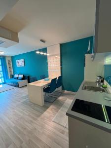 a kitchen and living room with a table and a couch at Balaton Vibe Apartman Füred in Balatonfüred