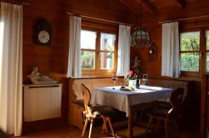 a dining room with a table with chairs and a clock at Blockhaus Rosa Reischl in Neubeuern