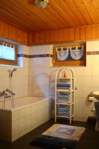 a bathroom with a bath tub and a sink at Blockhaus Rosa Reischl in Neubeuern +18 photos