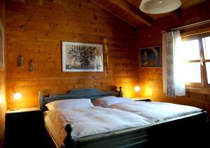 a bedroom with a bed in a wooden wall at Blockhaus Rosa Reischl in Neubeuern