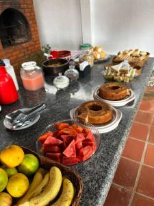 a counter with bowls of fruit and plates of food at Pousada Brisa do Oceano - Cumbuco in Cumbuco
