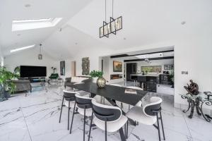 a living room with a dining table and chairs at Luxury Ascot Villa Steps from Royal Ascot, 5 mins to Legoland Windsor Resort, 10 mins to Windsor Castle in Ascot