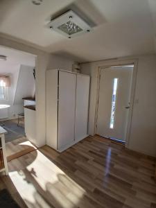 an empty room with a refrigerator and a door at Berghaga in Köping