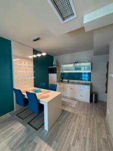 a kitchen with a table and blue chairs at Balaton Vibe Apartman Füred in Balatonfüred +6 photos