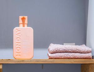 a bottle of lotion on a shelf next to a stack of towels at De Parel van Pekel in Nieuwe Pekela +40 photos