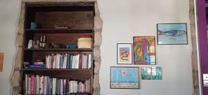 a book shelf with books and pictures on it at Quinta Maravista in Faial da Terra