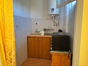 a small kitchen with a sink and a tv at Семейна къща Боеви in Pomorie