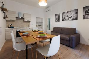 a kitchen and dining room with a wooden table and white chairs at Ottaviano Lodge in Rome
