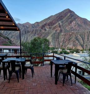 a patio with tables and chairs in front of a mountain at La Valentina in Purmamarca