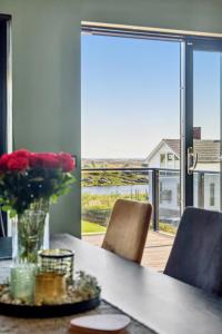 a dining room table with a vase of flowers and chairs at Moderne hus midt i Lofoten in Ballstad