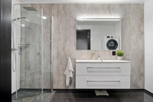 a bathroom with a sink and a shower at Moderne hus midt i Lofoten in Ballstad +20 photos